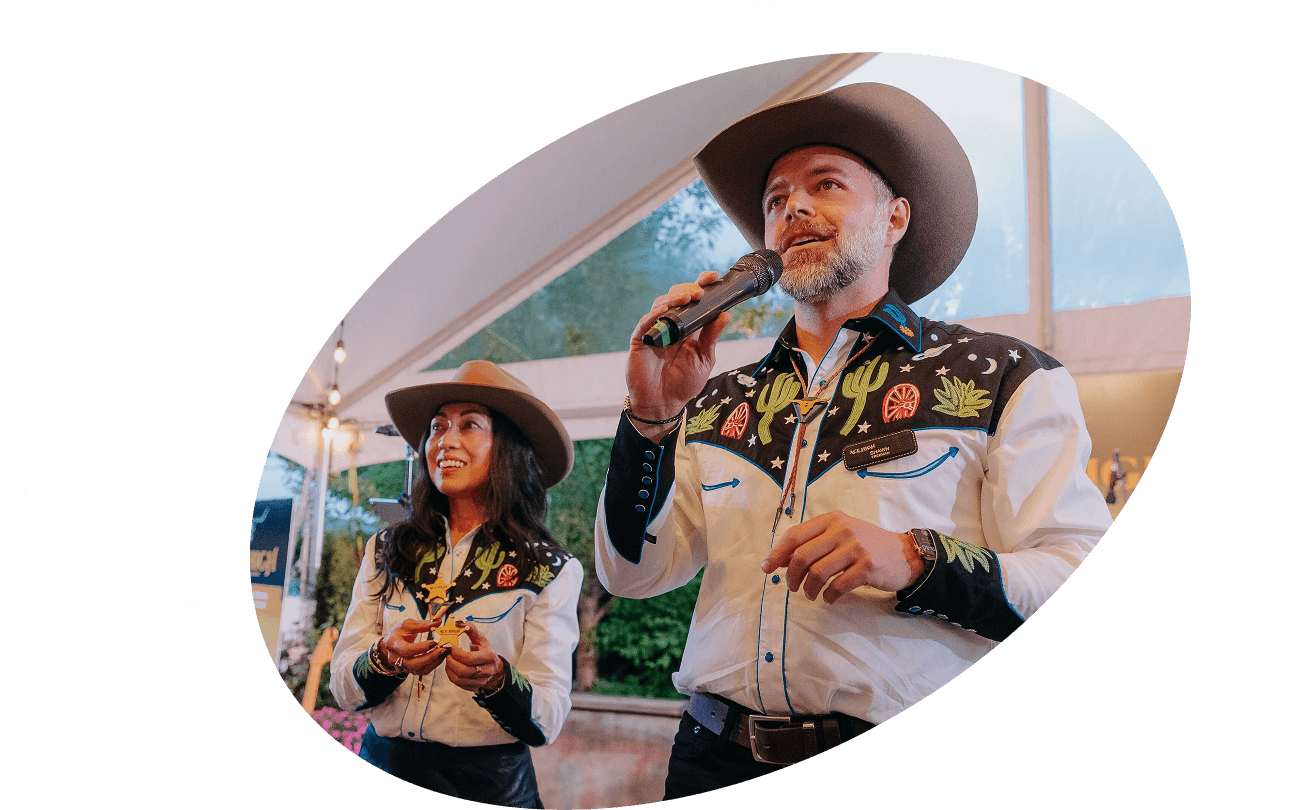 Two people in western-style shirts and cowboy hats speaking at an outdoor event, Calgary IT community banner image.