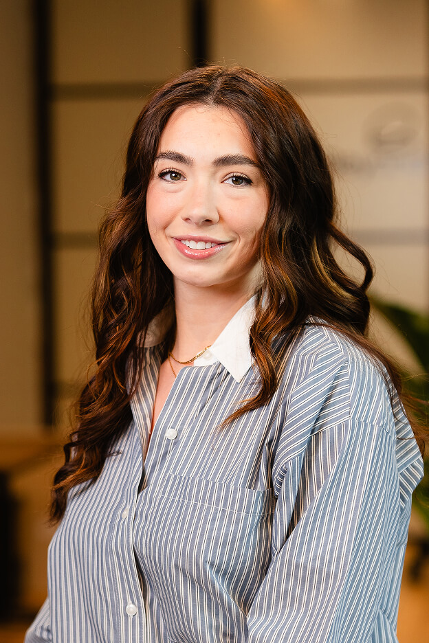 Team member Scarlett at Always Beyond wearing a striped shirt with long wavy hair in a Calgary IT office setting.